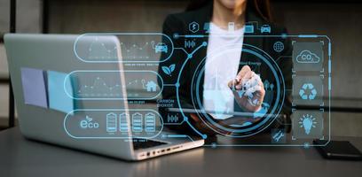 Businesswoman working virtual tablet computer twith reduce CO2 concept with icons, global warming such as reforest green factory recycle photo