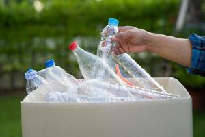 mujer participación el plastico botellas basura en caja a reutilizar reciclar para bueno ambiente. foto