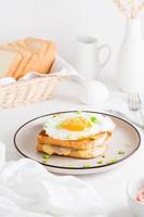 croque señora emparedado con queso, jamón y huevo en un plato en un ligero mesa. abundante hecho en casa desayuno. vertical ver foto