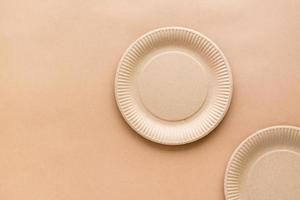 Cardboard empty plates on a beige background. Eco friendly and zero waste concept. Top view. photo