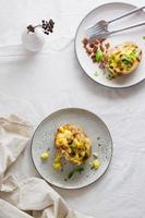 Appetizing twice-baked potatoes in their skins with cheese and bacon crumbs on plates on a wooden table. Flexitarian Diet. Top and vertical view photo