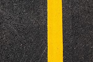 Yellow line on new asphalt detail,Street with yellow line texture photo