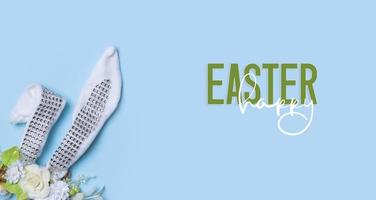 Happy Easter text with decorative easter banny ears and flowers. Easter greeting card or banner photo