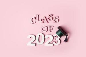 Class of 2023 concept. Wooden number 2023 with graduated cap on colored background. photo