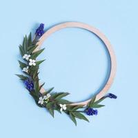 Round wooden frame with flower and leaves mock up flat lay for your text photo