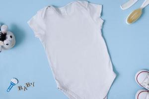 Mock up white baby bodysuit on a blue background. Your design or logo placement photo