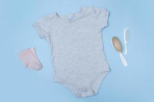 Flat lay mock up grey baby bodysuit on a blue background. Your design or logo placement photo