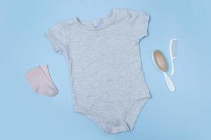 Flat lay mock up grey baby bodysuit on a blue background. Your design or logo placement photo