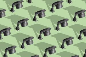 Pattern with black graduated cap on green background with hard shadow. Education background photo