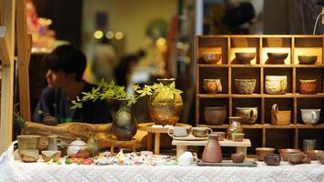 One little store for the plant and little mugs in a flea market photo