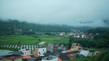 The beautiful countryside view from the runny train on the south of the China in the rainy day photo