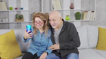 Alten Eltern Video chatten mit ihr Kinder auf das Telefon. reifen Senior Paar Video chatten auf Smartphone.