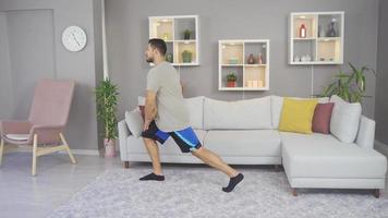 Exercise at home.  Young sporty male exercising in living room interior. video