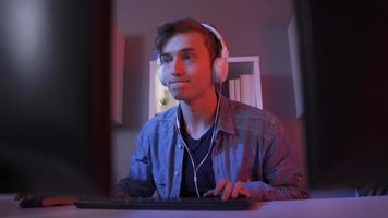 jovem homem jogando conectados atirador vídeo jogo. jovem bonito pró jogador jogando conectados Móvel jogos em dele computador. video