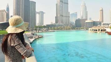 belle jeune femme caucasienne touriste bénéficie d'une vue panoramique depuis les piscines de la marina au centre-ville de dubaï. voyage visiter le concept de dubaï. tir de bannière en contre-plongée video