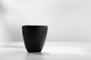 Black ceramic mug on a white table. photo
