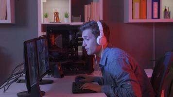 Jeune homme en jouant passionnant Jeu et en jouant en ligne vidéo Jeu avec ordinateur. professionnel esports joueur en jouant vidéo Jeu sur le sien ordinateur. video