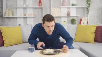 Hungry man is eating. Hungry man is eating and enjoying at home. video