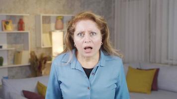 Mature woman is surprised. Sympathetic mature woman looks at camera and is surprised. video