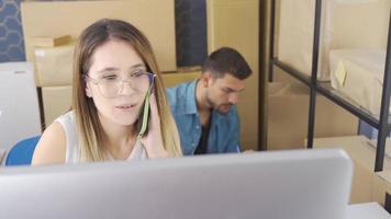 Female Marketer Using Computer While Checking Orders In E-Commerce Store. Businesswoman entrepreneur working on computer, preparing online parcel delivery boxes. SME concept. video