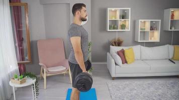 Strong Young Man Doing Exercise. Fit Athletic. Man exercising at home and working muscles with dumbbell weights. video
