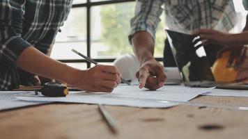 conceito de construção e estrutura de reunião de engenheiro ou arquiteto para projeto trabalhando com parceiros e ferramentas de engenharia na construção de modelo e projeto no local de trabalho, contrato para ambas as empresas. video