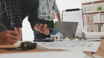 costruzione e struttura concetto di ingegnere o architetto incontro per progetto Lavorando con compagno e ingegneria utensili su modello edificio e planimetria nel Lavorando luogo, contrarre per tutti e due aziende. video