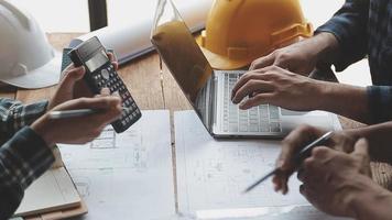 costruzione e struttura concetto di ingegnere o architetto incontro per progetto Lavorando con compagno e ingegneria utensili su modello edificio e planimetria nel Lavorando luogo, contrarre per tutti e due aziende. video