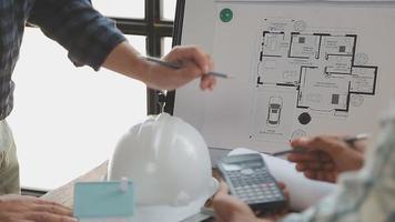 concepto de construcción y estructura de reunión de ingenieros o arquitectos para el proyecto que trabaja con socios y herramientas de ingeniería en la construcción de modelos y planos en el lugar de trabajo, contrato para ambas empresas. video