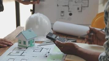 conceito de construção e estrutura de reunião de engenheiro ou arquiteto para projeto trabalhando com parceiros e ferramentas de engenharia na construção de modelo e projeto no local de trabalho, contrato para ambas as empresas. video