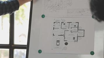 costruzione e struttura concetto di ingegnere o architetto incontro per progetto Lavorando con compagno e ingegneria utensili su modello edificio e planimetria nel Lavorando luogo, contrarre per tutti e due aziende. video