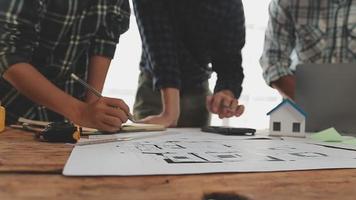 costruzione e struttura concetto di ingegnere o architetto incontro per progetto Lavorando con compagno e ingegneria utensili su modello edificio e planimetria nel Lavorando luogo, contrarre per tutti e due aziende. video