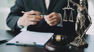 mannelijke advocaat die met contractdocumenten en houten hamer op tafel in rechtszaal werkt. justitie en recht, advocaat, rechter, concept. video
