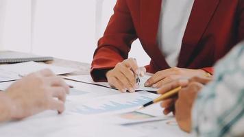 Teamwork of asian business people discussing and calculating with calculator on evaluation data in conference room. with the growth and pointing to the chart graph financial account. video