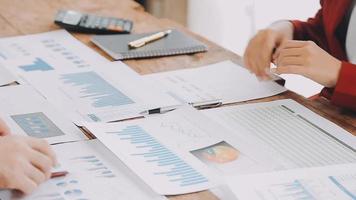 Teamwork of asian business people discussing and calculating with calculator on evaluation data in conference room. with the growth and pointing to the chart graph financial account. video