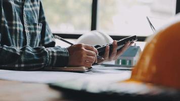 costruzione e struttura concetto di ingegnere Lavorando disegno su planimetria incontro per progetto Lavorando con compagno su modello edificio e ingegneria utensili nel Lavorando luogo, costruzione concetto video