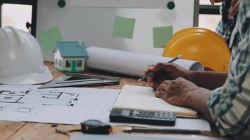 costruzione e struttura concetto di ingegnere Lavorando disegno su planimetria incontro per progetto Lavorando con compagno su modello edificio e ingegneria utensili nel Lavorando luogo, costruzione concetto video