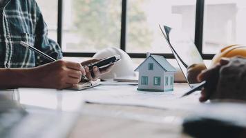 costruzione e struttura concetto di ingegnere Lavorando disegno su planimetria incontro per progetto Lavorando con compagno su modello edificio e ingegneria utensili nel Lavorando luogo, costruzione concetto video