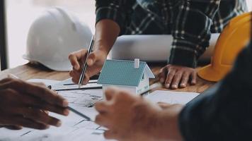 costruzione e struttura concetto di ingegnere Lavorando disegno su planimetria incontro per progetto Lavorando con compagno su modello edificio e ingegneria utensili nel Lavorando luogo, costruzione concetto video