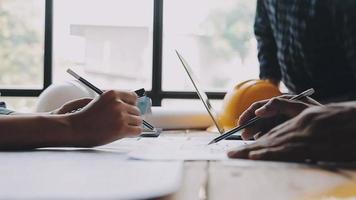 costruzione e struttura concetto di ingegnere Lavorando disegno su planimetria incontro per progetto Lavorando con compagno su modello edificio e ingegneria utensili nel Lavorando luogo, costruzione concetto video