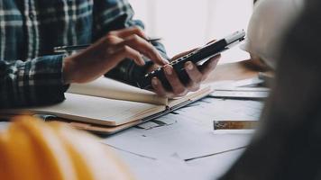 costruzione e struttura concetto di ingegnere Lavorando disegno su planimetria incontro per progetto Lavorando con compagno su modello edificio e ingegneria utensili nel Lavorando luogo, costruzione concetto video