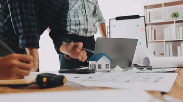 costruzione e struttura concetto di ingegnere Lavorando disegno su planimetria incontro per progetto Lavorando con compagno su modello edificio e ingegneria utensili nel Lavorando luogo, costruzione concetto video