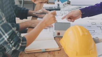 construcción y estructura concepto de ingeniero trabajando dibujo en Plano reunión para proyecto trabajando con compañero en modelo edificio y Ingenieria herramientas en trabajando sitio, construcción concepto video