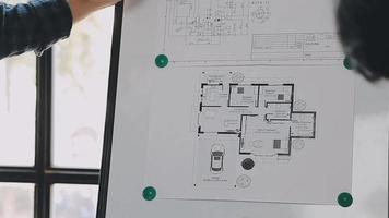 construcción y estructura concepto de ingeniero trabajando dibujo en Plano reunión para proyecto trabajando con compañero en modelo edificio y Ingenieria herramientas en trabajando sitio, construcción concepto video