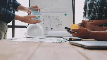 costruzione e struttura concetto di ingegnere Lavorando disegno su planimetria incontro per progetto Lavorando con compagno su modello edificio e ingegneria utensili nel Lavorando luogo, costruzione concetto video