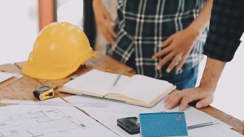 costruzione e struttura concetto di ingegnere Lavorando disegno su planimetria incontro per progetto Lavorando con compagno su modello edificio e ingegneria utensili nel Lavorando luogo, costruzione concetto video