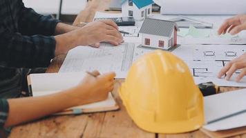 costruzione e struttura concetto di ingegnere Lavorando disegno su planimetria incontro per progetto Lavorando con compagno su modello edificio e ingegneria utensili nel Lavorando luogo, costruzione concetto video