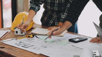 costruzione e struttura concetto di ingegnere Lavorando disegno su planimetria incontro per progetto Lavorando con compagno su modello edificio e ingegneria utensili nel Lavorando luogo, costruzione concetto video