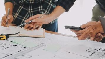 costruzione e struttura concetto di ingegnere Lavorando disegno su planimetria incontro per progetto Lavorando con compagno su modello edificio e ingegneria utensili nel Lavorando luogo, costruzione concetto video