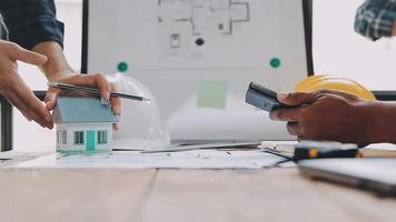 costruzione e struttura concetto di ingegnere Lavorando disegno su planimetria incontro per progetto Lavorando con compagno su modello edificio e ingegneria utensili nel Lavorando luogo, costruzione concetto video